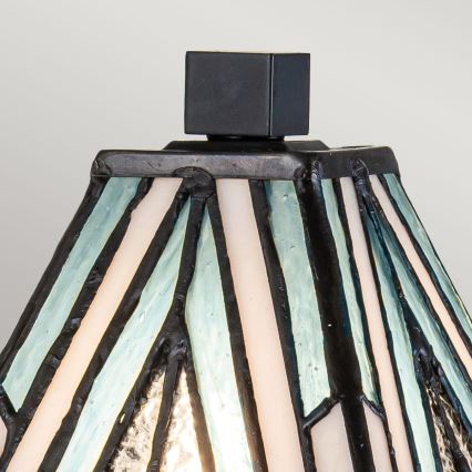 Lampa s tienidlom z farebného skla s bielymi a svetlomodrými pruhmi rozdelenými čiernou olovou, zakončeným čiernym štvorcovým vrchnákom.