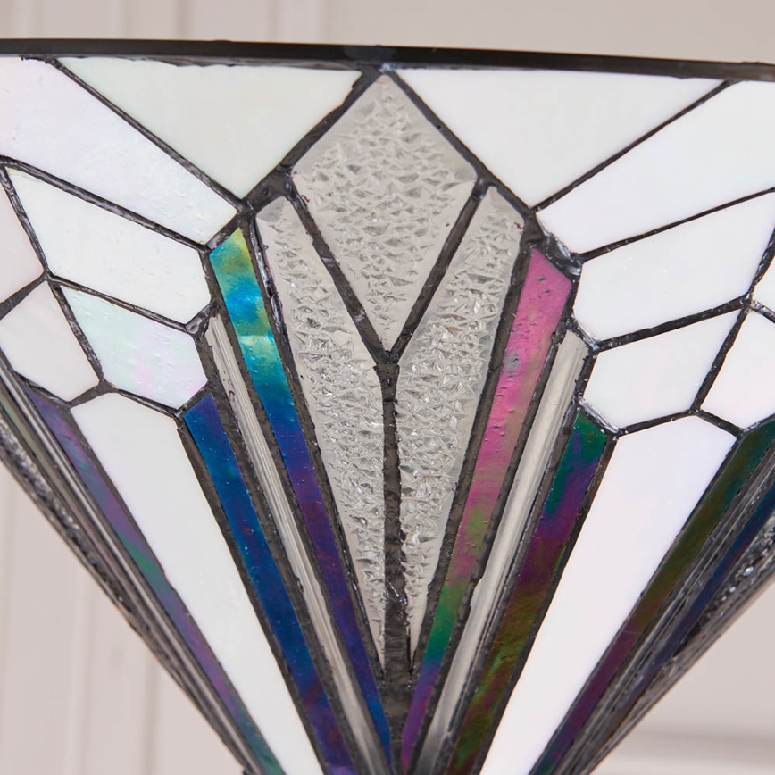 Tienidlo v tvare kosoštvorca s farebnými sklenenými panelmi sa rozkladá smerom dole. Štruktúra je zložená z číreho a mliečneho skla s tmavými kovovými lemovými linkami. Svetlo prechádza sklenenými panelmi.