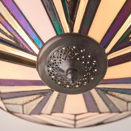 Stropné svetlo s tienidlom z farebného skla, ktoré je pripevnené k kovovému základu s perforáciou. Svetlo vyžaruje z vnútornej strany tienidla, ktoré je tvorené mnohými farebnými pruhmi.