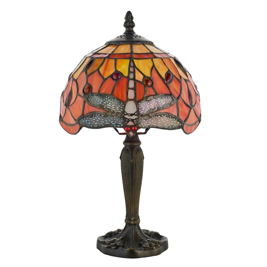 Stolová lampa s tienidlom z farebného skla zobrazuje vážku. Tienidlo je oranžovo-žlté s tmavohnedou kovovou nohou a podstavcom. Lampa je umiestnená na bielom pozadí.
