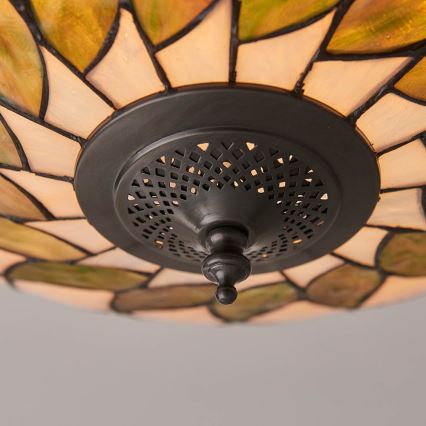 Svietidlo s tienidlom z farebného skla pripevnené k stropu. Tienidlo je zdobené listovitými tvarmi. Svietidlo je pripevnené k stropu pomocou kovového držiaka s perforáciou.