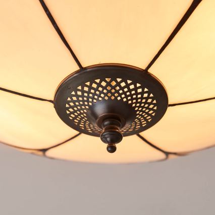 Svietidlo s mliečnym tienidlom zo skla s tmavými kovovými líniami je pripevnené k stropu. Spodná časť tienidla má tmavý kovový dekoračný prvok s perforovaným vzorom.