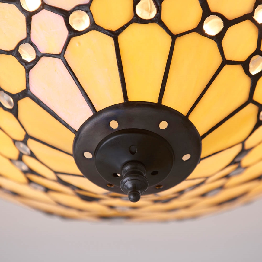 Svietidlo je pripevnené k stropu. Jeho tienidlo je z farebného skla, s geometrickým vzorom, svetložlté s priehľadnými časťami. Tienidlo má okrúhly tvar. Čierny kovový držiak drží tienidlo.