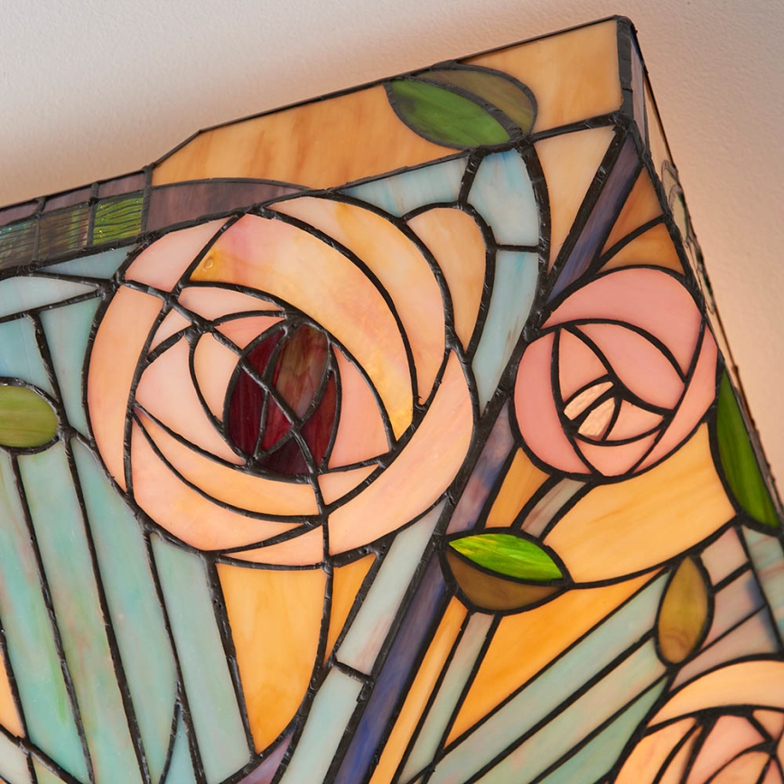 štvorcová vitrážová lampa zobrazuje ruže v štýle Art Nouveau, je pripevnená k stropu. Farebnosť je teplá, s odtieňmi ružovej, oranžovej a modrej.