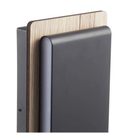 Stenová svietidlo je umiestnené na stene. Svietidlo má tmavosivý predný panel a drevený vrchný panel. Je zjavne moderného dizajnu.