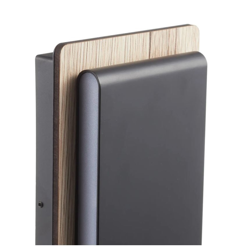 Stenová svietidlo je umiestnené na stene. Svietidlo má tmavosivý predný panel a drevený vrchný panel. Je zjavne moderného dizajnu.