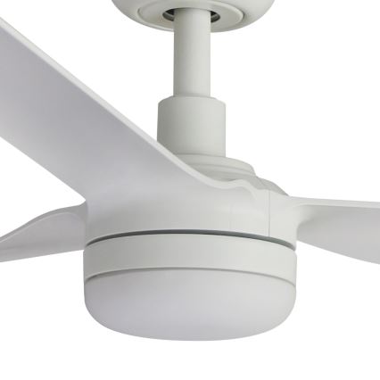 Biely stropný ventilátor s tromi lopatkami sa otáča. Lopaty sú dlhé a úzke. Ventilátor je pripevnený k stropu bielym držadlom.