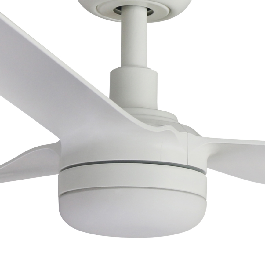 Biely stropný ventilátor s tromi lopatkami sa otáča. Lopaty sú dlhé a úzke. Ventilátor je pripevnený k stropu bielym držadlom.
