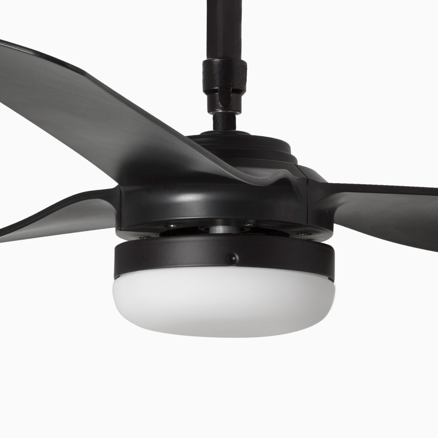 Čierny stropný ventilátor s tromi lopatkami rotuje. Má zabudované biele osvetlenie. Je umiestnený na bielom pozadí.