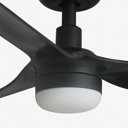 Čierny stropný ventilátor s tromi lopatkami a zabudovaným bielym svetlom. Ventilátor je pripevnený k stropu a jeho lopatky sú v pokoji. Je zobrazený na bielom pozadí.