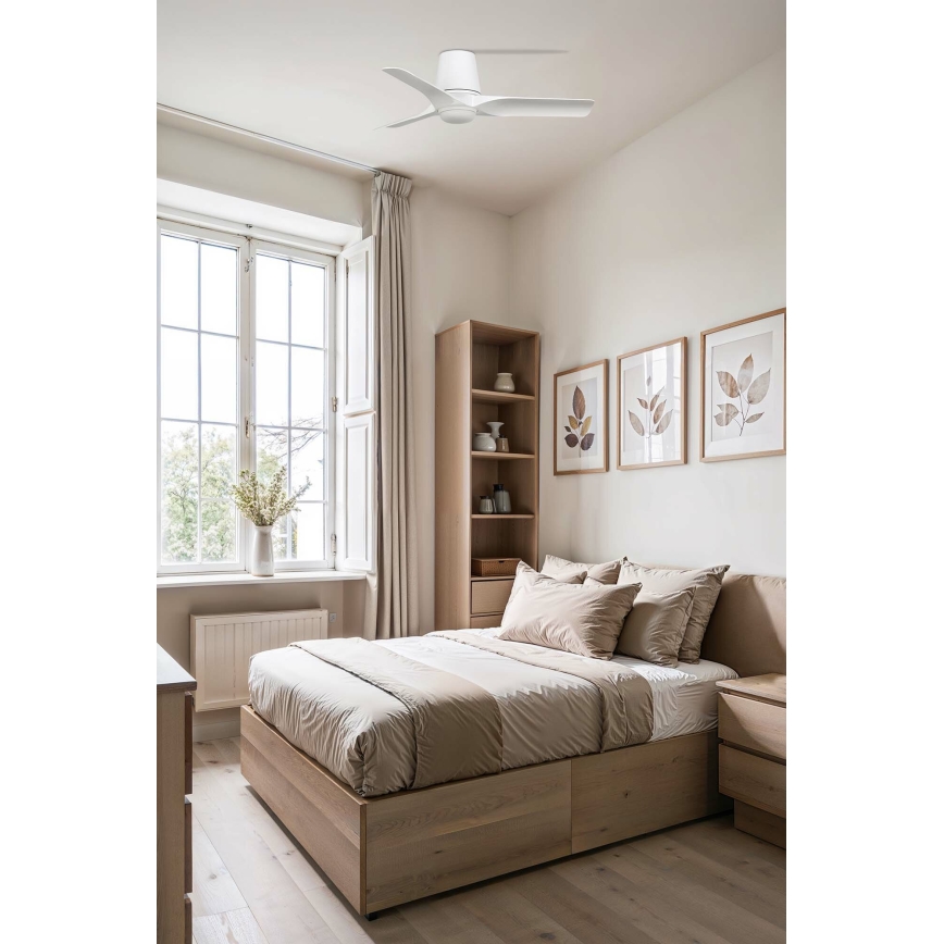 Biely stropný ventilátor s troma lopatkami sa otáča v spálni. Spálňa obsahuje posteľ s úložným priestorom, nočný stolík, knihovňu a okno s závesmi. Na stene visia tri obrazy s listami.