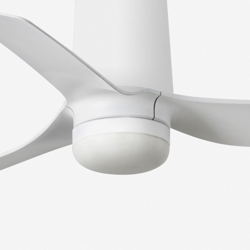 Biely stropný ventilátor s troma lopatkami sa nachádza v bielom priestore. Lopatky sú pripevnené k bielemu stĺpiku. Ventilátor je zhotovený z hladkého materiálu.