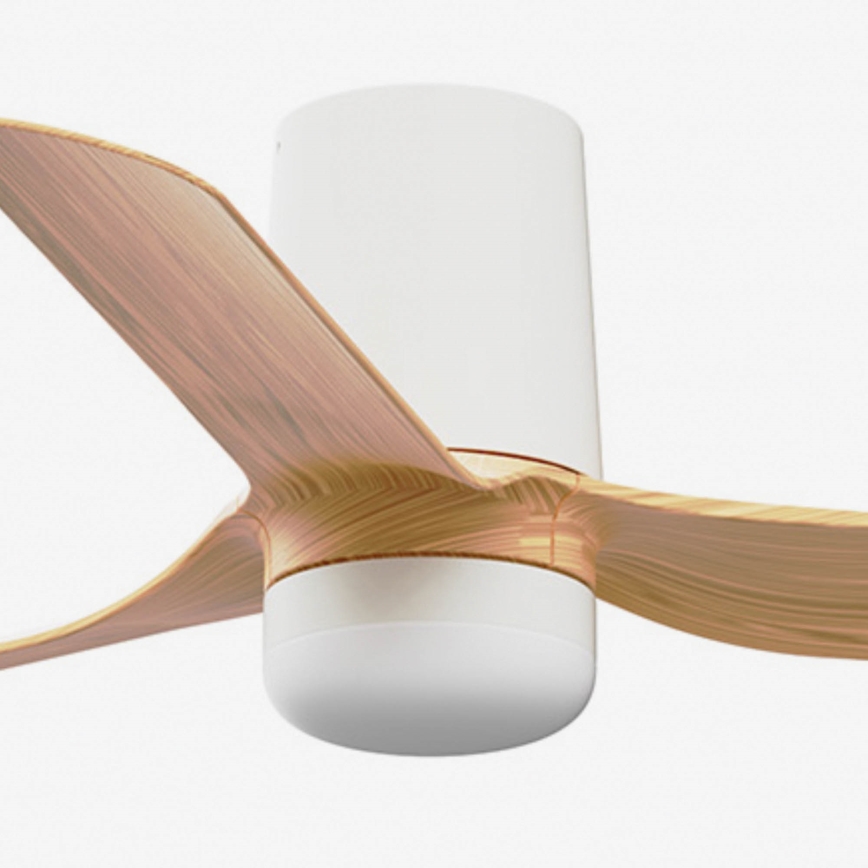 Stropný ventilátor s drevenými lopatkami a bielym stredom rotuje. Lopaty sú svetlohnedé, s výraznou drevenou štruktúrou. Ventilátor je zavesený na bielom podstavci.