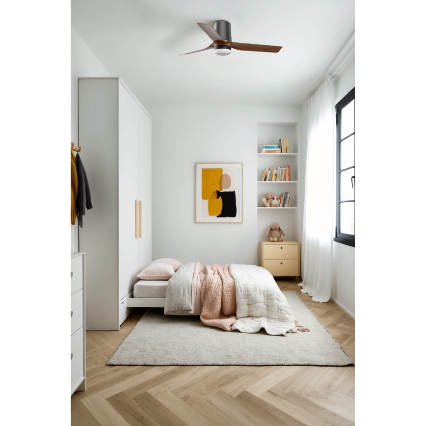 Stropný ventilátor sa otáča v detskej izbe. Izba obsahuje posteľ s prikrývkou, vstavanú skriňu, knižnicu a koberec na podlahe z drevených lamiel.