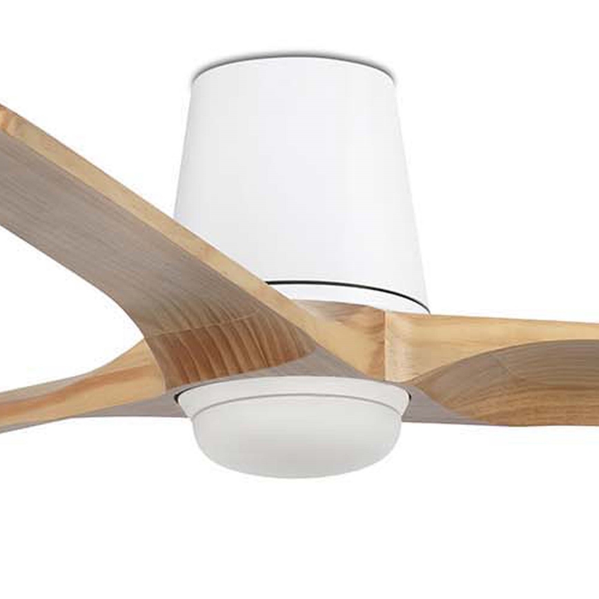 Drevený stropný ventilátor s tromi lopatkami sa otáča. Biele kryty motora a ložísk kontrastujú s hnedými drevenými lopatkami. Ventilátor je umiestnený v interiéri.