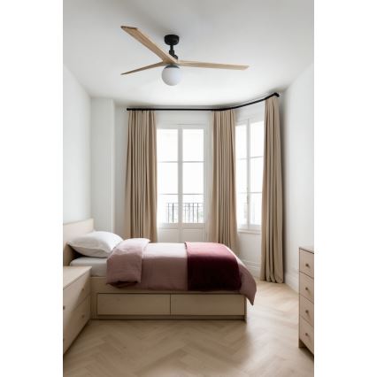 Drevený stropný ventilátor s osvetlením sa nachádza v spálni. Posteľ s bledoružovou prikrývkou a vínovočerveným prehozom je umiestnená pred oknom so svetlými závesmi. Podlaha je z dreva v rybej kosti.