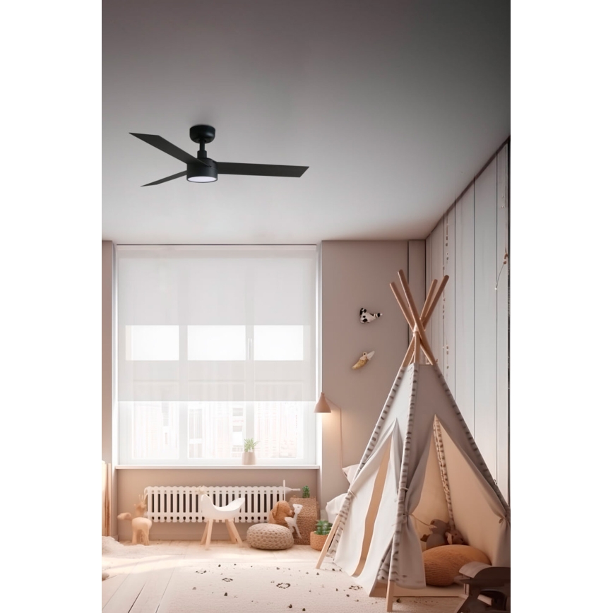 Čierny stropný ventilátor s tromi lopatkami sa otáča v detskej izbe. Izba obsahuje detské hračky, indiánsky stan a okno so závesom.