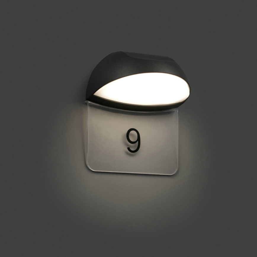 Svietidlo osvetľuje číselný štítok s číslom 9. Svietidlo je pripevnené na stenu.