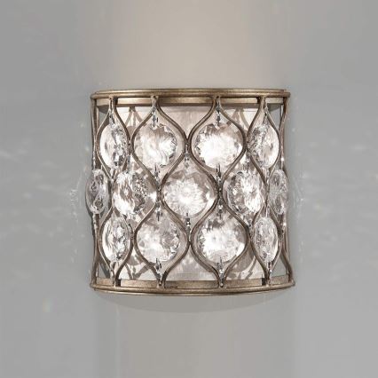 Nástenná lampa je pripevnená na stene. Je valcovitého tvaru s kovovou konštrukciou a kryštáľovými ozdobami. Vnútorný textilný difúzor je svetlej farby.