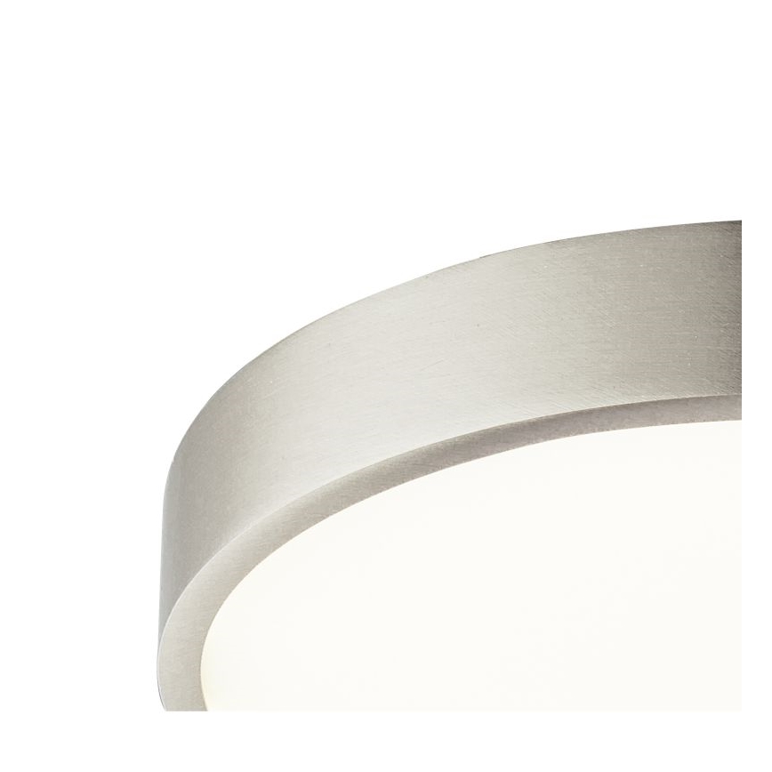 Stropné svietidlo svieti. Má strieborný kovový rám a difúzor z matného skla. Je pripevnené k stropu.