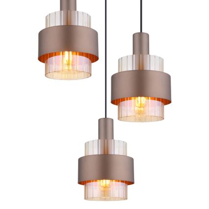Tri bronzové závesné lampy s priehľadnými segmentovanými difúzormi a žiarovkami visia z čiernych káblov pred bielym pozadím.