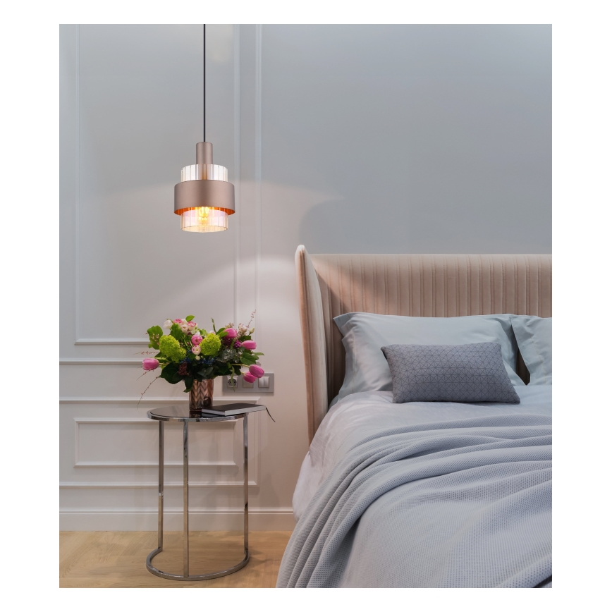 Svietidlo visí v spálni. Je dvojdielne, kovové v zlatej farbe, s priehľadnou sklenenou časťou. Nachádza sa nad nočným stolíkom s kvetmi a vedľa postele s posteľnou bielizňou.