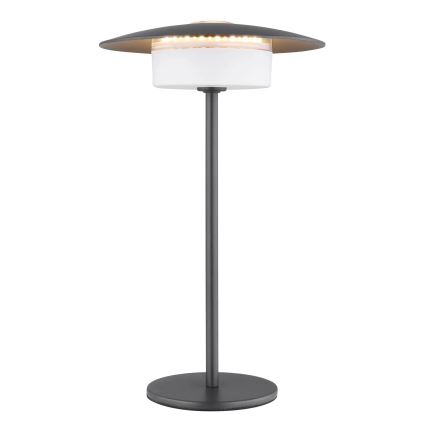 Stolová lampa s tmavosivou kovovou nohou a tienidlom, ktoré obsahuje LED diódy, svieti na bielom difúzore. Lampa stojí na kruhovej podstave.