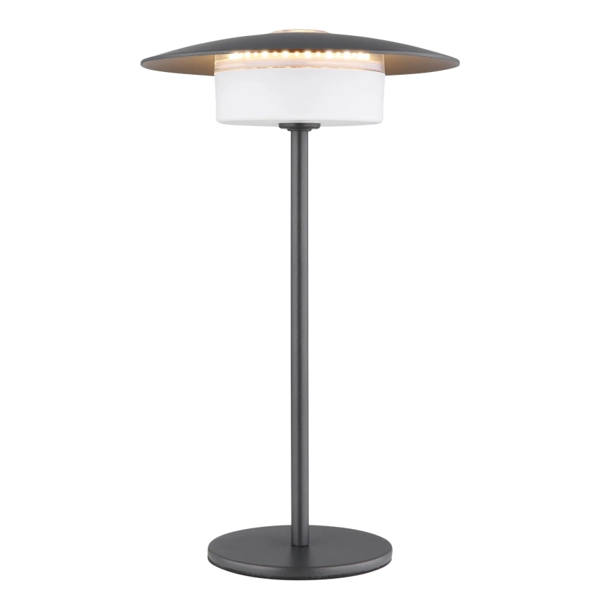 Stolová lampa s tmavosivou kovovou nohou a tienidlom, ktoré obsahuje LED diódy, svieti na bielom difúzore. Lampa stojí na kruhovej podstave.