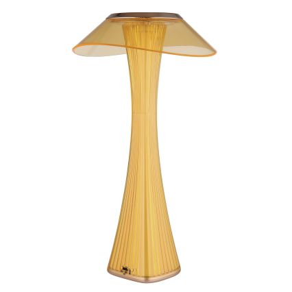 Stolová lampa so žltým tienidlom v tvare huby svieti. Jej telo je vysoké, úzke a rebrované. Stojí na bielom pozadí.