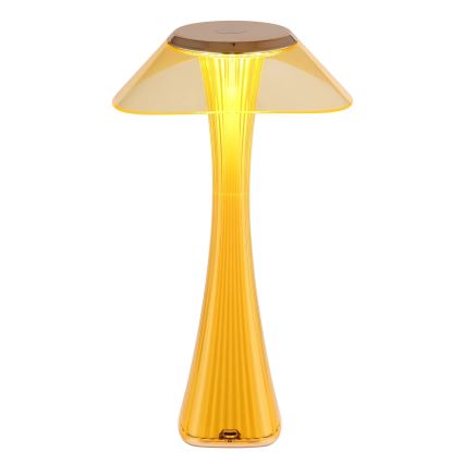 Žltá stolová lampa s tvarom huby svieti. Má široký, priesvitný tienidlo a vysoké, rebrované telo. Je umiestnená na bielom pozadí.