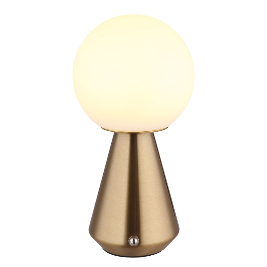 Stolová lampa svieti. Jej tienidlo je guľaté, mliečne biele. Podstavec je kužeľovitý, zlatohnedej farby. Na spodku podstavca sa nachádza vypínač.