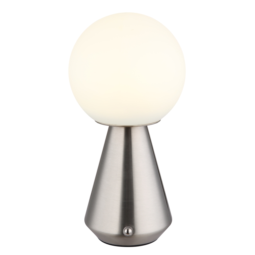 Stolná lampa svieti. Jej tienidlo je guľaté, mliečne biele, umiestnené na štíhlom, kužeľovitom, striebornom podstavci s vypínačom na spodku. Lampa je na bielom pozadí.