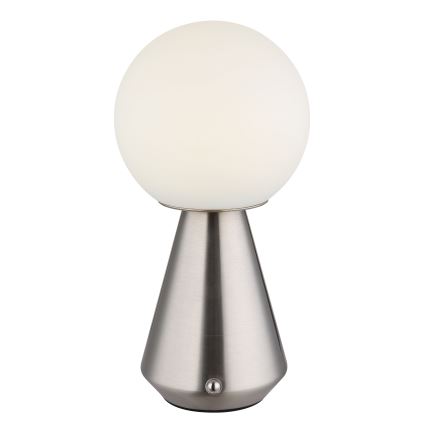 Stolová lampa s bielou guľovou tienidlom a strieborným kužeľovitým podstavcom s vypínačom na spodku. Lampa svieti. Na bielom pozadí.