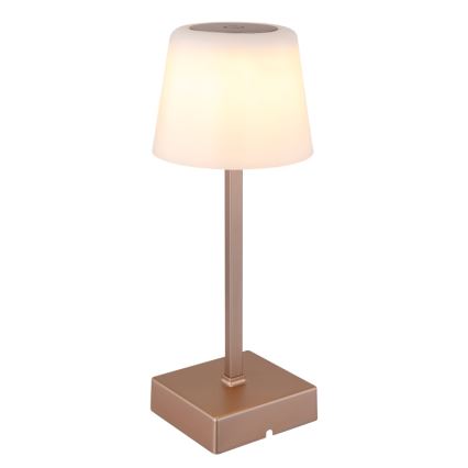 Stolná lampa svieti. Má medenú kovový stĺpik a štvorcovú základňu, na vrchu je priehľadná mliečne biela tienidlo.