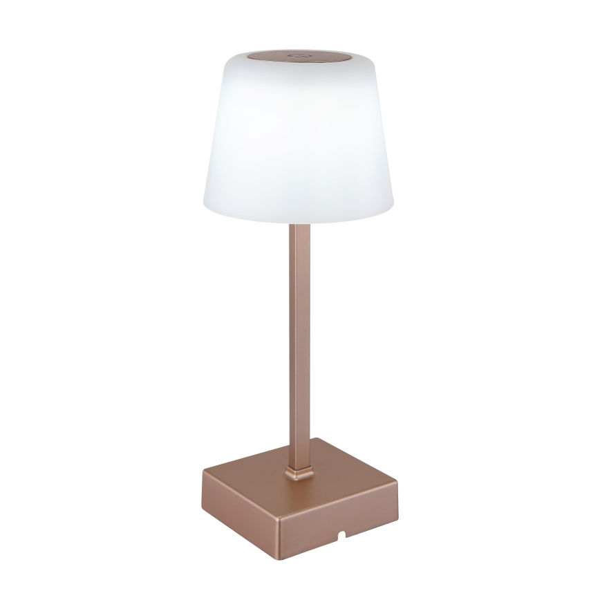 Stolová lampa s bielym tienidlom v tvare valca a ružovo-zlatou kovovou základňou a stĺpikom. Lampa stojí na štvorcovej podstave.