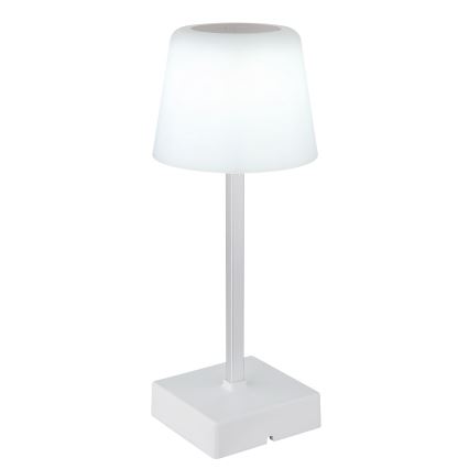 Stolná lampa s bielym tienidlom v tvare zrezaného kužeľa a striebornou nohou stojí na bielej štvorcovej podstave. Lampa je umiestnená na bielom pozadí.