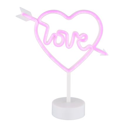 Ružová neónka v tvare srdca s nápisom „love“ prechádza šípka. Svietiaca dekorácia stojí na bielej podstavke.