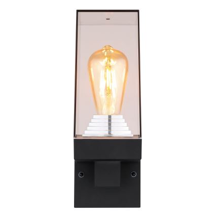Nástenná lampa svieti. Je umiestnená na stene, v tvare obdĺžnika, s priesvitným sklom a viditeľnou žiarovkou typu Edison.