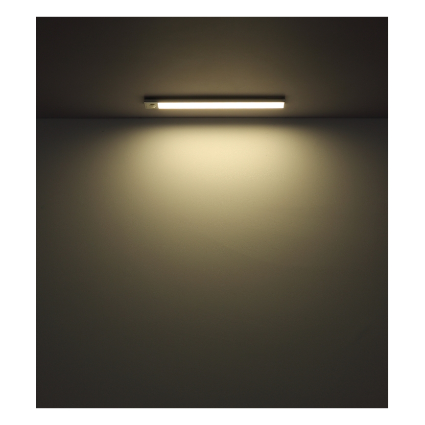 LED pásik osvetľuje stenu. Pásik je pripevnený na strope v tmavej miestnosti. Svetlo pásika sa šíri po stene.