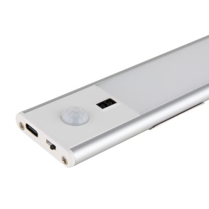 LED svietidlo s pohybovým senzorom je umiestnené na bielom pozadí. Svietidlo má strieborný hliníkový rám a obsahuje USB-C port.