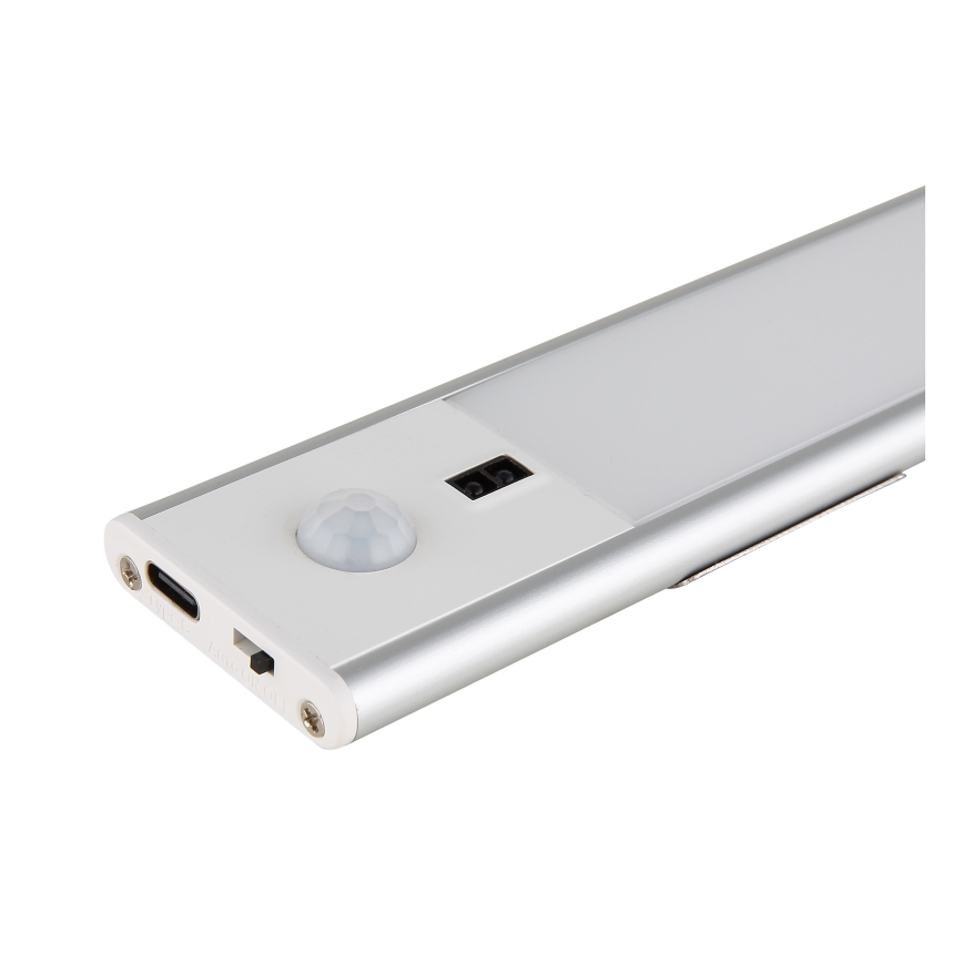 LED svietidlo s pohybovým senzorom je umiestnené na bielom pozadí. Svietidlo má strieborný hliníkový rám a obsahuje USB-C port.
