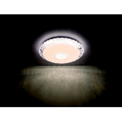 Svietidlo svieti na strope. Je okrúhle, priehľadné s vnútorným svetlým diskom. Svetlo sa odráža na stene pod ním.