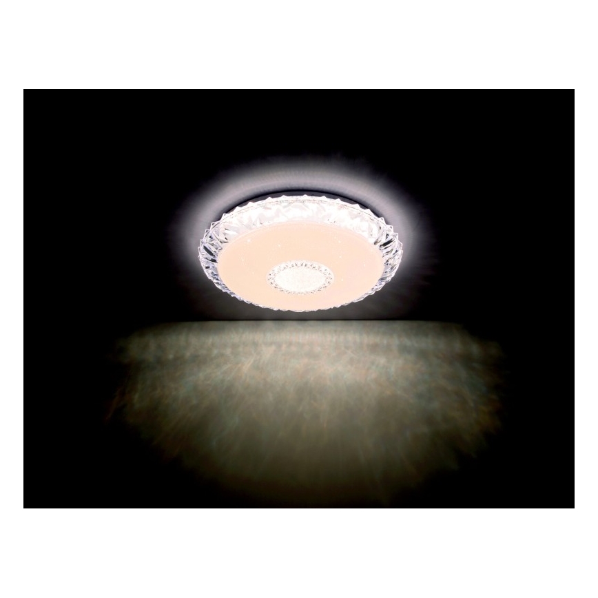 Svietidlo svieti na strope. Je okrúhle, priehľadné s vnútorným svetlým diskom. Svetlo sa odráža na stene pod ním.