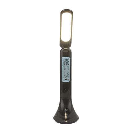 Stolová lampa svieti. Na jej prednej strane je digitálny displej zobrazujúci čas 12:08, dátum 1/1 a deň TUE, teplotu 24.9 stupňov. Lampa stojí na bielom pozadí.