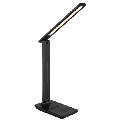 Čierna skladacia stolná lampa s LED osvetlením. Lampa je v rozloženej polohe, svieti. Stojí na rovnej ploche.