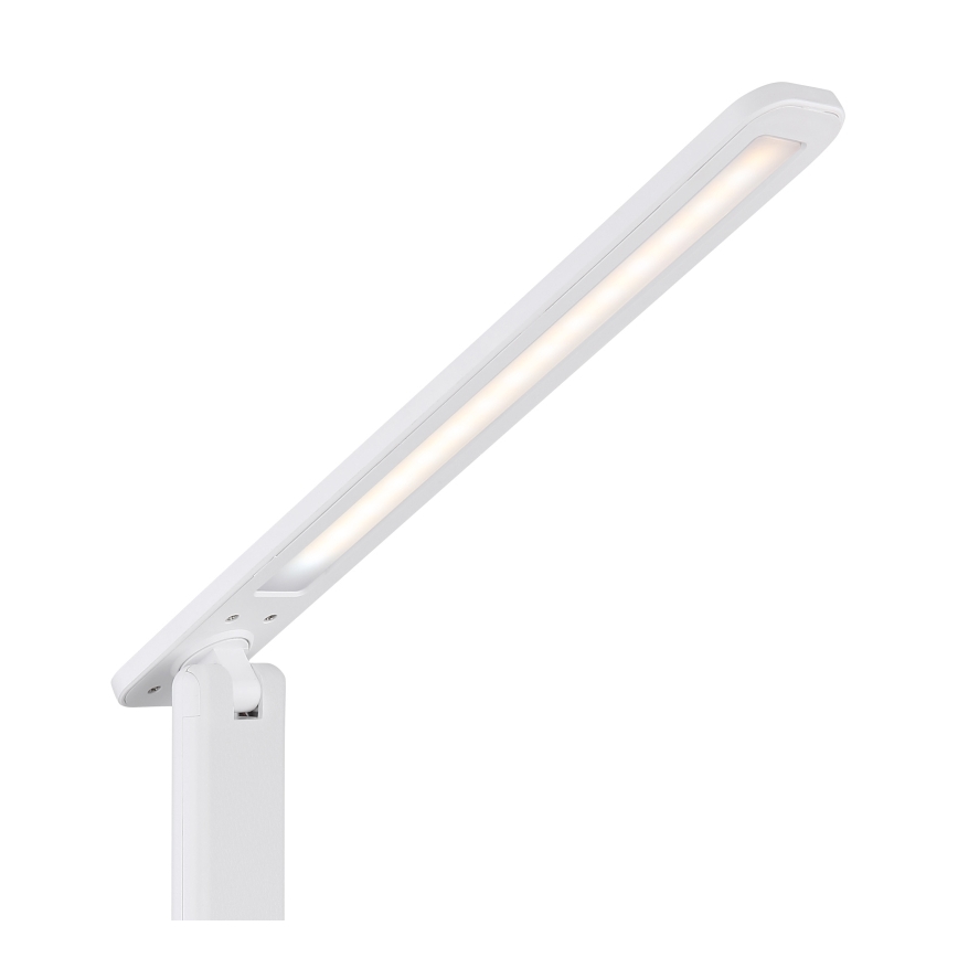 Biela stolná lampa s LED osvetlením svieti. Rameno lampy je výsuvné a otočné. Lampa je umiestnená na bielom podstavci.