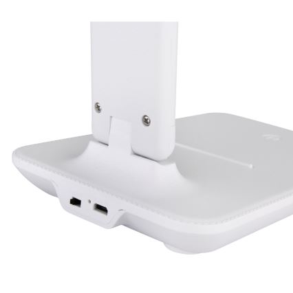 Biela stolová lampa s nabíjacou stanicou je zložená. Na základni sú viditeľné dva USB porty – USB-A a USB-C.