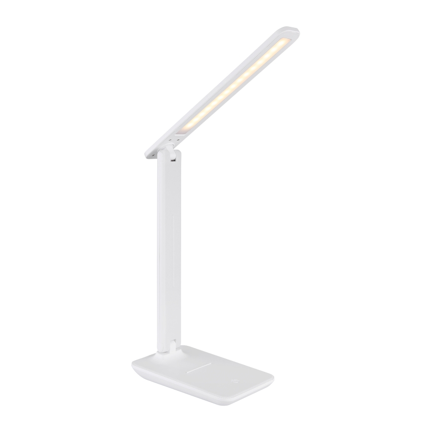 Biela stolová lampa s LED osvetlením svieti. Lampa je skladacia s dlhým, úzkym ramenom. Stojí na plochej, širokej základni.