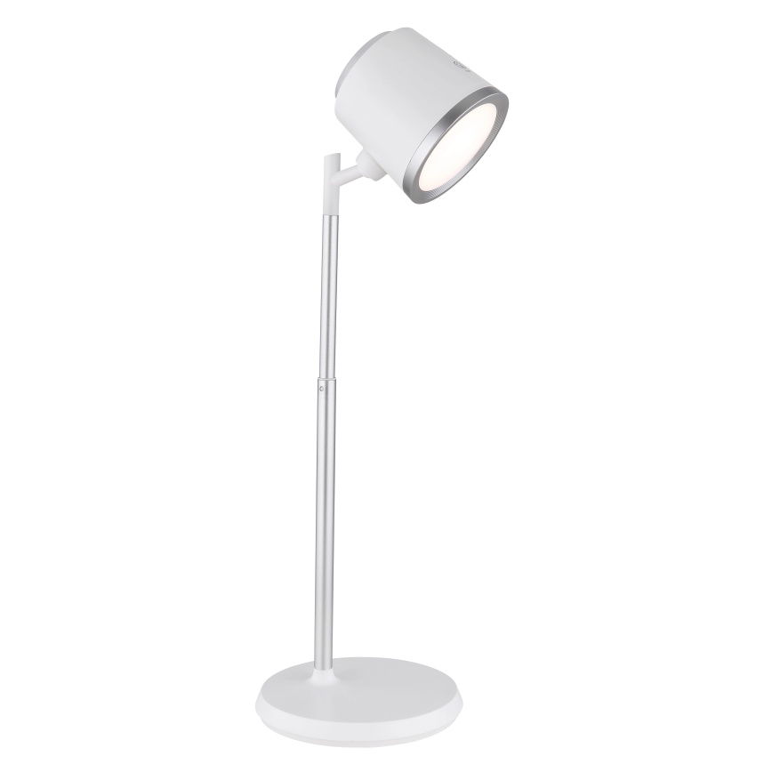 Biela stolná lampa s nastaviteľným ramenom a okrúhlou základňou svieti. Svietidlo je kovové, strieborno-biele.