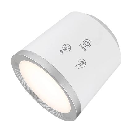 Valcovité LED svetlo svieti. Na jeho vrchu sú tlačidlá: ON/OFF, DIM, CCT. Svetlo je prevažne biele s strieborným lemom.